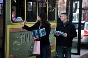 image of holiday shoppers exchanging packages with trolley riders