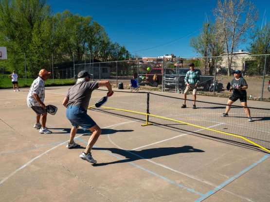 four people playing pickleball